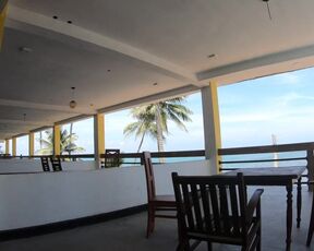 Nude lady ambles on the balcony disregarding the ocean