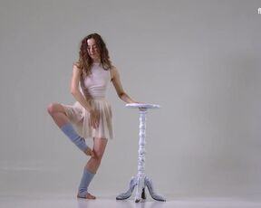 Hot flexible dancer with curly hair. Taking off her clothes during a workout routine
