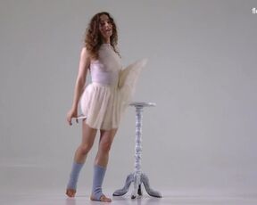 Hot flexible dancer with curly hair. Taking off her clothes during a workout routine