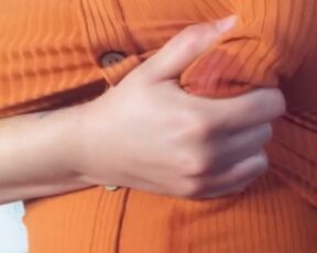 A fat woman in an orange blouse. Lactation through clothes and display of large milk boobs