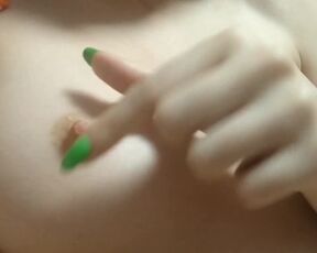 A naughty young girl's finger with a bright manicure play with her nipples