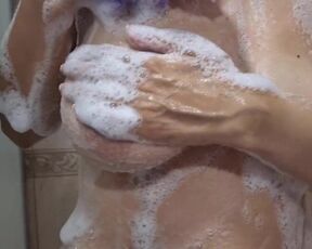 Sexy MILF with big natural tits plays in the shower.