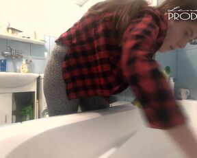 The housewife washes the bathtub. Her boobs are peeking out of her unbuttoned shirt