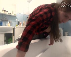 The housewife washes the bathtub. Her boobs are peeking out of her unbuttoned shirt