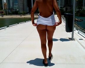 Summer walk in the city flashing her tits from under her shirt