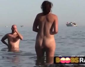 Curvy lady is entirely nude on the beach and getting prepped to get into the water