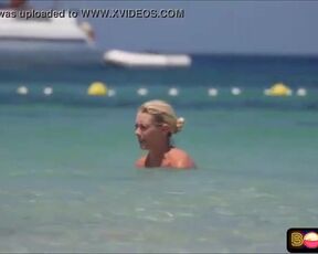 Bare-Chested damsel doesn't give a sex that everyone is gawping at her boobies, on the beach