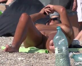 Nude dame is loving on a naturist beach and opening up up to showcase her shaven beaver