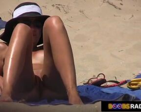 Horny voyeur is recording a video, while naughty girls are lying naked on the beach