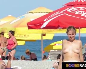 Attractive brunette is smoking a cigarette on the beach, while a horny voyeur is watching